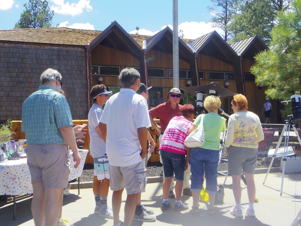 Photo of people lined up to look at the sun through a solar telescope. Photo credit: Karen Maddy